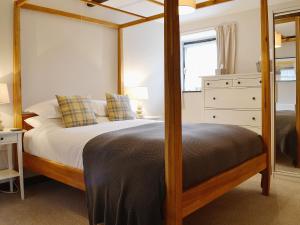 a bedroom with a bed with a wooden frame at The Buttery in Marros