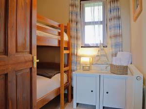 a bedroom with bunk beds and a desk with a lamp at The Buttery in Marros