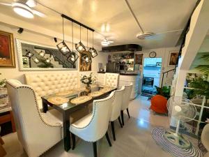 a dining room with a table and white chairs at The White Haven In Clark ENTIRE HOUSE in Angeles