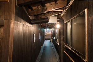 an empty hallway with wooden walls and stairs in a building at Yachi Onsen in Towada