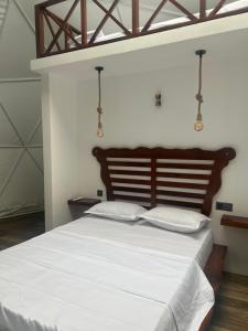 a bedroom with a large bed with white sheets at Sinharaja Geo Dome in Nelluwa
