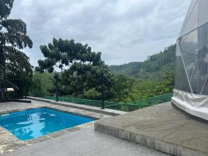 a swimming pool on the side of a building at Sinharaja Geo Dome in Nelluwa +4 photos