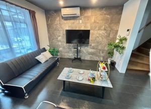 a living room with a couch and a table at HOTTOSTAY OoGANE in Nagoya