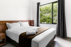 a bedroom with a bed and a large window at Shencasa Living Juanda in Siwalam 2