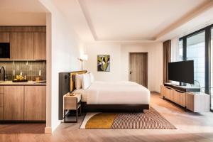 a hotel room with a bed and a flat screen tv at Kennedy 89 Hotel Frankfurt, part of Hyatt in Frankfurt