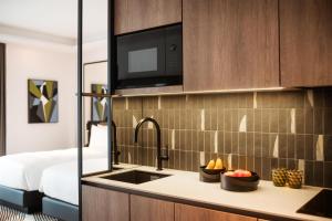 a kitchen with a sink and a microwave at Kennedy 89 Hotel Frankfurt, part of Hyatt in Frankfurt +145 photos