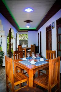 a dining room with a wooden table and chairs at Guru Guest House in Trincomalee