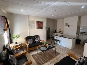 a living room with a couch and a table at Martinique Guesthouse in Kathu