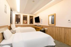 a hotel room with two beds and a tv at Yeongdeungpo Komodo Hotel in Seoul