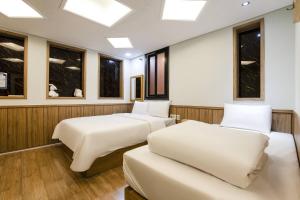 two beds in a room with windows at Yeongdeungpo Komodo Hotel in Seoul +46 photos