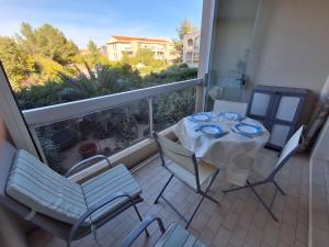 a balcony with a table and chairs on a balcony at Soleil d'or à St Aygulf in Fréjus +9 photos