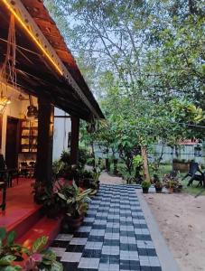 a patio of a house with a black and white tile floor at marari adonis beach villa in Mararikulam