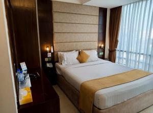 ein Hotelzimmer mit einem Bett und einem großen Fenster in der Unterkunft White Park Hotel & Suites in Chittagong