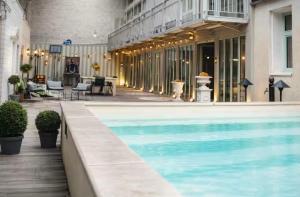 a swimming pool in front of a building at Maison bonheur -Parking- piscine -espace de jeux- avec 6 suites avec SDB in Bourg-en-Bresse