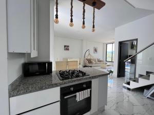 a kitchen with a stove top oven next to a counter at Imperial Emerald House in Muzo