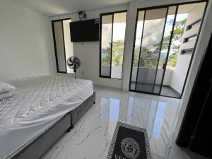 a bedroom with a bed with marble floors and windows at Imperial Emerald House in Muzo