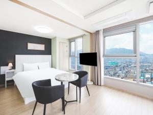 a hotel room with a bed and a table and chairs at Elmomento Sasang in Busan