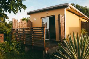 a small house with a wooden deck in a yard at Chambre d'hôte La Kazanou in Saint-Joseph