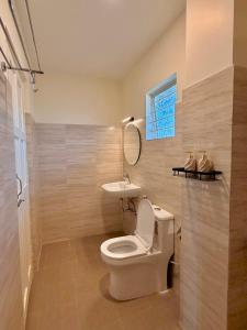 a bathroom with a toilet and a sink and a mirror at Barylia in Mawlyngkhung +31 photos