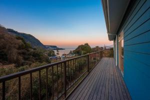 a balcony of a house with a view of the ocean at Umi no SOBA 伊豆 - BBQ & Sauna in Ito