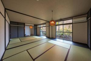 an empty room with large windows and a room with white floors at Umi no SOBA 伊豆 - BBQ & Sauna in Ito