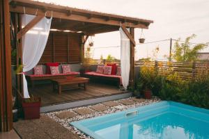 a backyard deck with a pool and a pergola at Chambre d'hôte La Kazanou in Saint-Joseph
