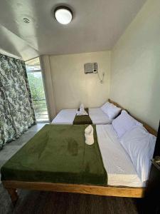 a bedroom with a large bed in a room with a window at Samaravilla in Tagbilaran City +7 photos