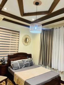 a bedroom with a bed and a chandelier at Samaravilla in Tagbilaran City
