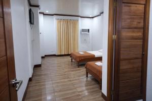 a small room with two beds and a door at La Elliana Hotel & Restaurant, Inc. in Laoag