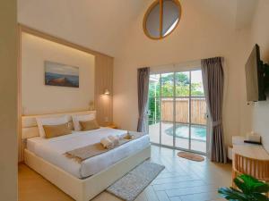 a bedroom with a large bed and a balcony at Rabbit Villa Bangsaray in Bang Sare