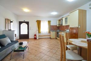 a kitchen and living room with a couch and a table at APARTMANI DELAS in Pješčana Uvala