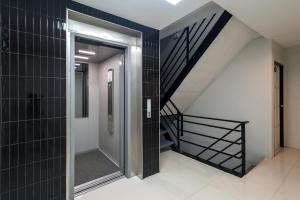a hallway with black tiled walls and a staircase at Tiya House Rooms & Cafe in Krabi