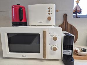 a microwave oven with a coffee maker on top of it at Cozystay-Beomeo in Hyomoktong-Ilgu