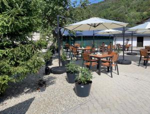 a patio with tables and chairs and umbrellas at Casa Veche in Runcu