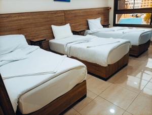 a group of three beds in a room at فندق الشلالات العقبه Waterfalls Hotel Aqaba in Aqaba