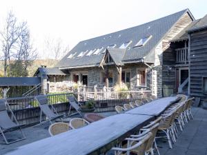 a patio with chairs and a long table in front of a house at Vielsalm Stay with furry friends in Vielsalm