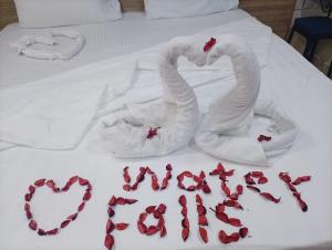 two swans made out of towels on a bed at فندق الشلالات العقبه Waterfalls Hotel Aqaba in Aqaba +35 photos