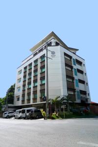 a large white building with cars parked in front of it at Star Hotel Davao in Davao City