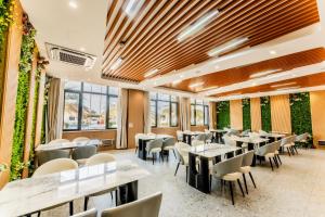 a restaurant with tables and chairs and plants at Beijing Daxing Apartment in Ban Doung