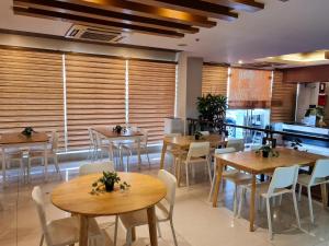 a restaurant with wooden tables and white chairs at Star Hotel Davao in Davao City