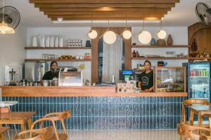 two women standing behind a bar in a restaurant at Tiya House Rooms & Cafe in Krabi +20 photos