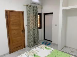 a room with a door and a bed and a window at Modern studio close to the TER train station in Dakar