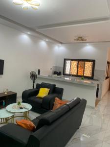 a living room with two couches and a tv at Modern studio close to the TER train station in Dakar