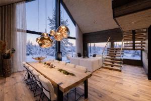 a dining room with a table and a large window at AURA Arctic Chalets - Grand Panoramic & Grand Hideaway in Saariselka