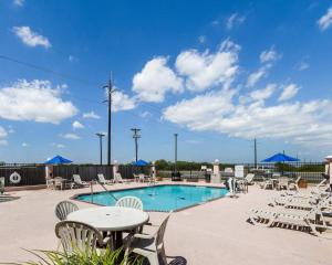 a swimming pool with chairs and a table at Quality Inn Ingleside - Corpus Christi in Ingleside