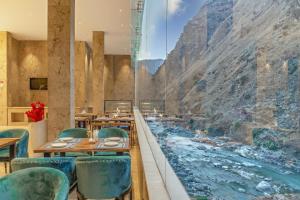 a restaurant with a view of a river at Echor Palm Bliss Resort & Spa, Kasol in Kasol +77 photos