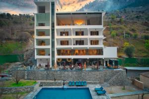 a building with a swimming pool in front of it at Echor Palm Bliss Resort & Spa, Kasol in Kasol