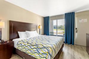 a hotel room with a bed and a window at Rodeway Inn Orange Park - Jacksonville near Naval Air Station in Orange Park