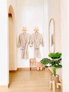 a room with three suits hanging on a wall at Rabbit Villa Bangsaray in Bang Sare