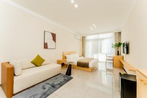 a living room with a couch and a bed at Beijing Daxing Apartment in Ban Doung